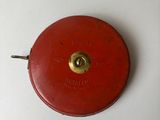 une horloge rouge posée sur une table blanche