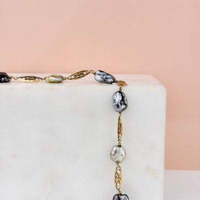 a close up of a necklace on a marble block