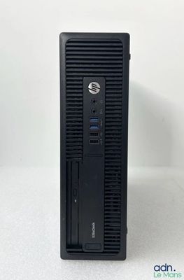 un ordinateur de bureau noir posé sur une surface blanche