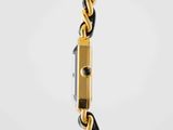 a close up of a gold and black watch on a white background
