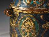 a close up of a blue and gold container on a white surface