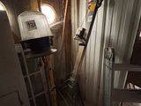 une pièce dans laquelle se trouvent une échelle, une fenêtre et une lampe
