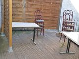 tables and chairs on a wooden deck with a fence in the background