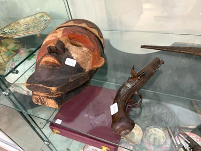une vitrine contenant un masque, un pistolet et d'autres objets