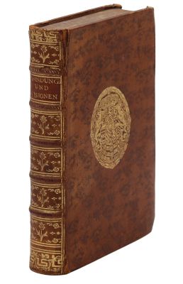 an old book with a gold medallion on the front of it