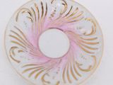 a white plate with a pink and gold design on it
