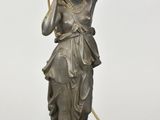 an antique bronze statue of a woman holding a bird on a stand