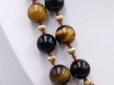 a close up of a necklace with tiger ' s eye beads on a mannequin
