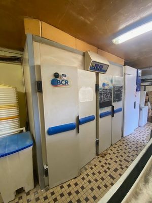 une rangée de réfrigérateurs dans une cuisine au sol en damier