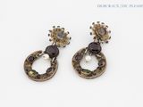 paire de boucles d'oreilles ornées de grenats et de perles sur un fond blanc