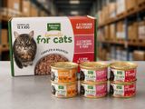 quatre boîtes de nourriture pour chat posées sur une table à côté d'un carton de nourriture pour chat