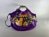 purple purse with a lot of things inside of it on a white surface