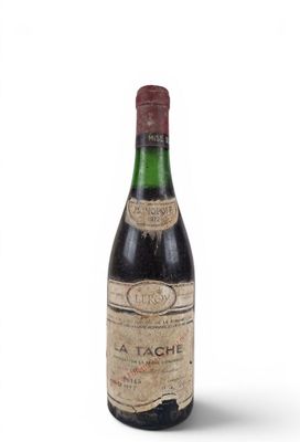 an old bottle of wine sitting on top of a white surface