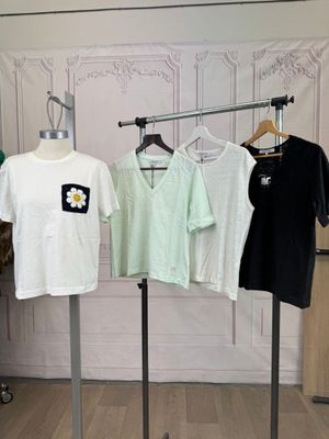 trois t-shirts suspendus à un portant dans une pièce