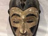 an image of a wooden mask hanging on a wall
