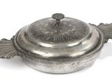 a silver pot with a lid on a white surface