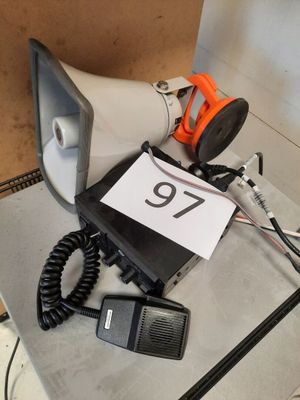 un micro, un haut-parleur et une pancarte posée sur une table