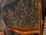 a black jacket with a gold and orange design on it
