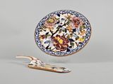 une assiette ornée d'un motif floral, à côté d'une cuillère en bois