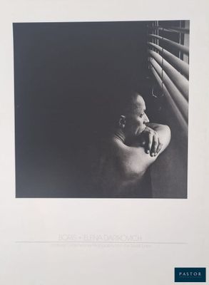 a black and white photo of a woman leaning against a window