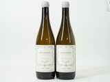 deux bouteilles de vin blanc posées l'une à côté de l'autre sur une surface blanche