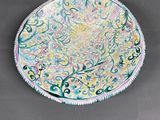 painting of a plate with a floral design on it on a gray surface