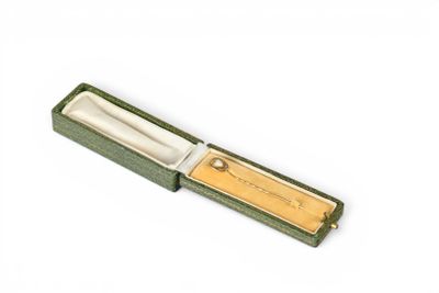 a small knife in a green box on a white surface