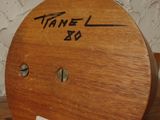a wooden clock on a shelf with writing on it