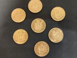 six pièces de six livres sterling disposées sur une surface noire