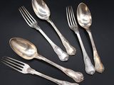 five silver spoons and a fork on a black surface