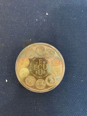 a gold coin with a picture on it on a blue surface