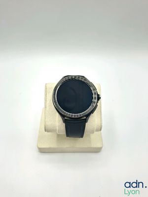 une photo d'une montre connectée posée sur un socle blanc