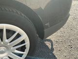 une voiture noire aux jantes blanches garée sur un parking
