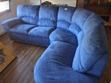a blue couch in a living room with a wooden floor