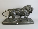 bronze statue of a lion on a base on a white background