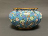a blue vase with flowers on it sitting on a table