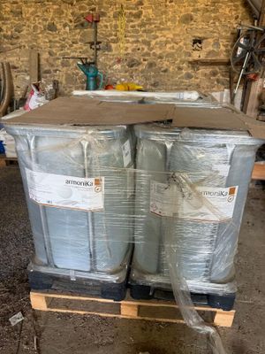two large drums sitting on a pallet in a garage