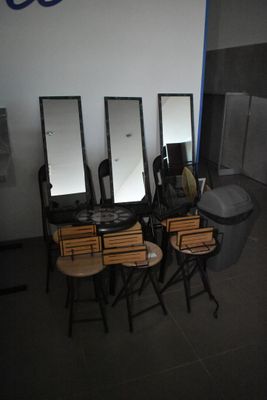 une pièce avec beaucoup de chaises et des miroirs accrochés au mur
