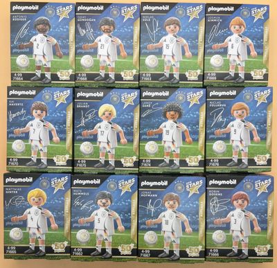 Plusieurs boîtes de figurines Playmobil sur le thème du football sont empilées les unes sur les autres