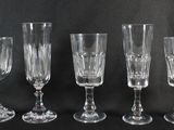 quatre verres à vin sont alignés sur une surface noire