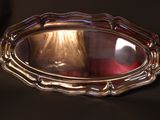 a silver tray with a candle in it on a table