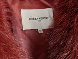 un gros plan sur un manteau de fourrure rouge portant une étiquette