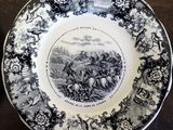 a black and white plate with a picture of a man riding a horse