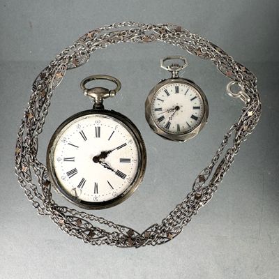 a silver pocket watch with a chain around it and a silver pocket watch with a chain around it