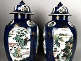 pair of blue and white vases with asian scenes on them