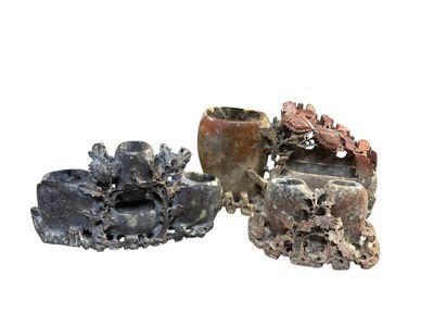 trois vases posés l'un à côté de l'autre sur une surface blanche