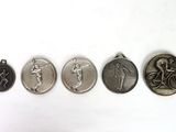 four medals of different sizes and shapes are shown on a white surface