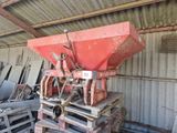 a red spreader sitting on top of a pallet in a warehouse