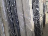 many mattresses wrapped up in plastic in a warehouse