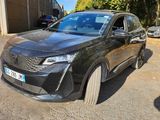 une voiture noire garée dans un parking à côté d'un bâtiment